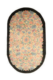 Vintage Chinese Art Deco rug, 83x49 inches (210x125 cm), featuring intricate floral patterns in pastel coral, blue, and mauve on an ivory background, framed by a bold black oval border.